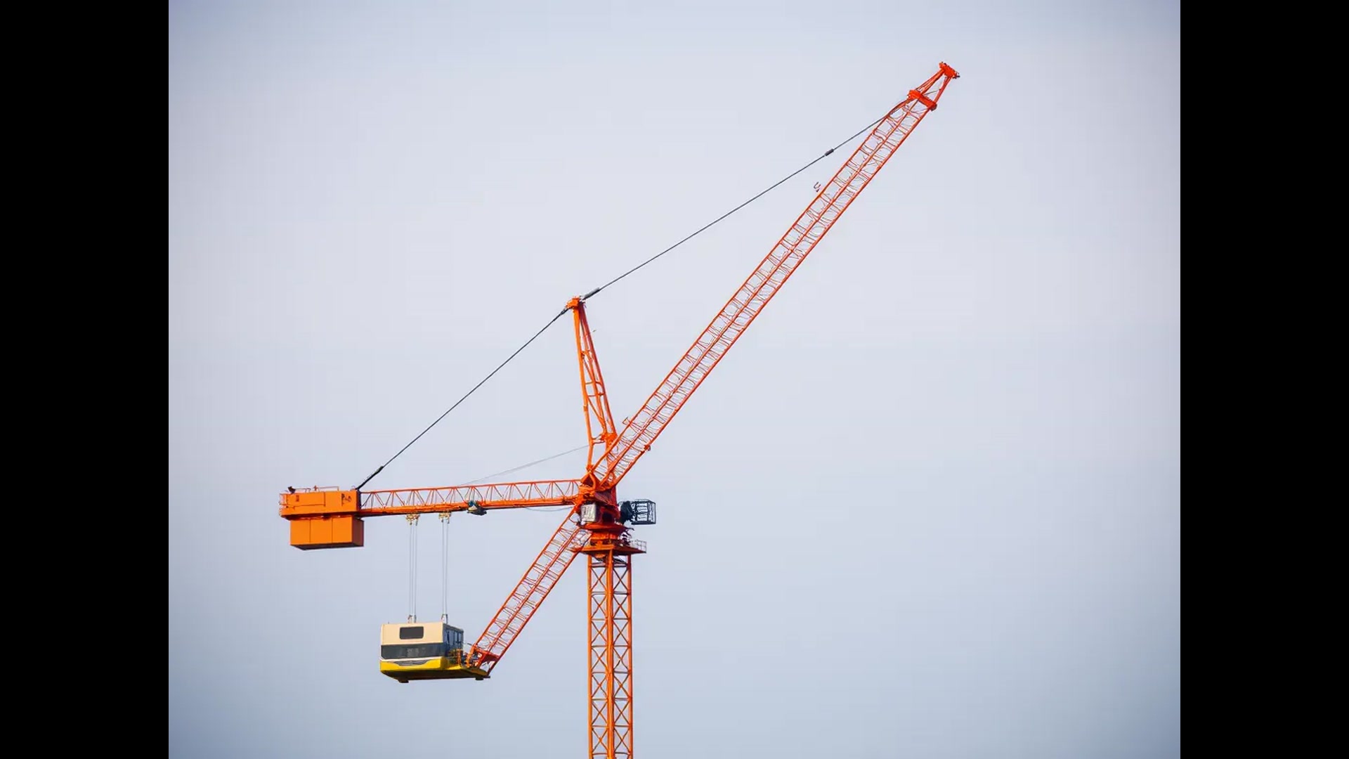 Professional mobile crane truck at construction site with industrial equipment and construction workers